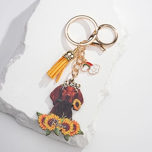 Close-up of personalized dog keychain with sunflower, yellow tassel, and rainbow charm