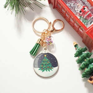 Christmas tree keychain with green leather tassel and sequin ball on white background