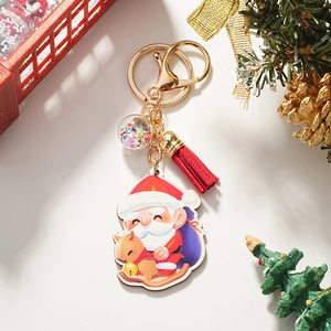 Detail of Christmas Santa and reindeer keychain with red tassel and gold metal ring