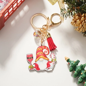 Detail of Christmas gnome keychain with red tassel, star-filled sequin ball, and golden clasp