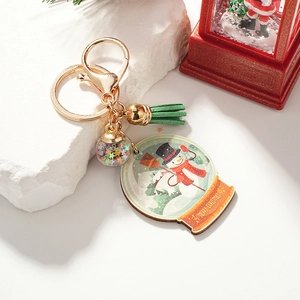 Christmas snowman keychain with colorful star sequins ball and green tassel on stone