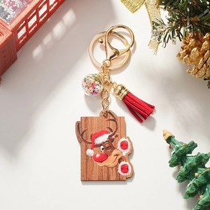 Detail of Christmas reindeer wooden keychain with red tassel and sparkling glass ball charm