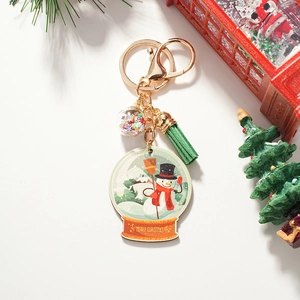 Detail of Christmas snowman keychain with green tassel and Merry Christmas slogan