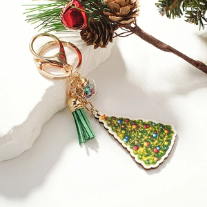 Christmas tree wooden keychain with green tassel and star filled orb on white stone
