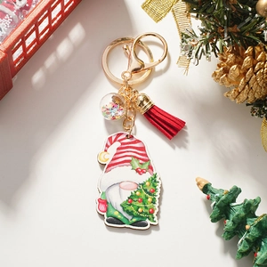 Detail of Christmas gnome keychain with red tassel and sequin ball on a festive background
