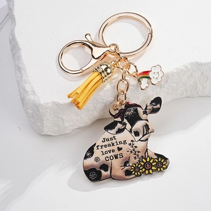 Detail of keychain with yellow tassel, rainbow cloud, and cow printed acrylic pendant