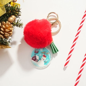 Christmas snowman acrylic keychain with red pom pom and green tassel on white background