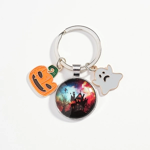 Halloween keychain with enamel pumpkin, ghost, and glass castle charm on white background
