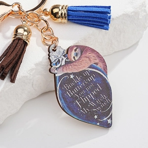 Close-up of sloth acrylic keychain with colorful tassels and humorous slogan detail