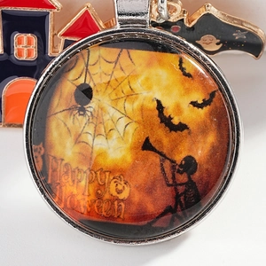Halloween keychain with round glass pendant featuring bat, skeleton, and spider web design