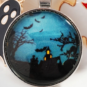 Halloween keychain featuring a blue castle and bat silhouette inside a glass pendant