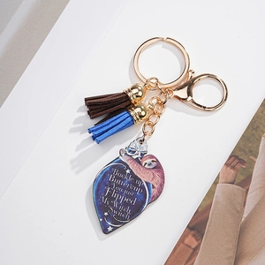 Detailed view of sloth acrylic keychain with gold clasp and blue and brown tassels
