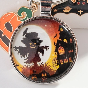 Halloween keychain featuring yellow scarecrow castle glass pendant and pumpkin bat charms