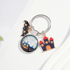 Halloween keychain with black bat, pumpkin glass cabochon, and purple castle charms