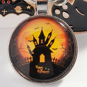 Halloween keychain with spooky castle and bats under orange moon in glass dome