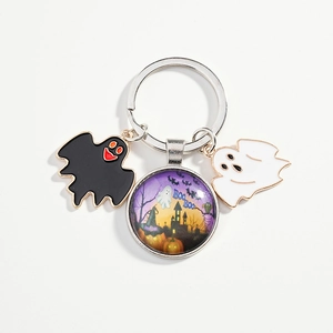 Halloween keychain with purple spooky castle glass pendant and ghost charms on white backdrop