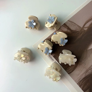 Gros plan de mini pinces à cheveux papillon et fleur avec perles sur un magazine mode