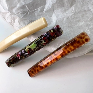 Detailed view of floral, pearly white and tortoiseshell acetate hair barrettes clips set