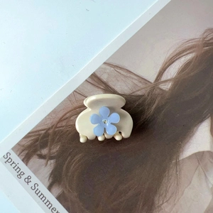 Vue détaillée d'une pince à cheveux en acétate avec fleur bleue pour coiffures élégantes