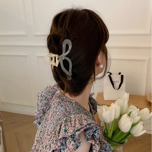Elegant large translucent smoky gray bow hair claw clip styled on woman's head