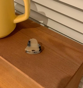 Close-up of a heart-shaped marble acetate hair claw clip on a warm wooden surface