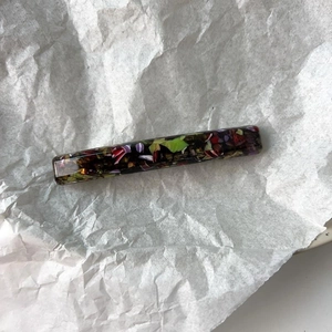Rectangular resin hair clip with colorful mosaic fragments on white paper