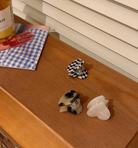 Three-piece heart hair clips in checkerboard, amber, and pearl white patterns