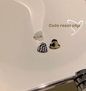 Detailed view of three resin heart mini hair clips in white, checkered, and tortoise patterns