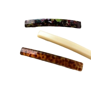 Three acetate hair clips in pearl white, tortoiseshell, and colorful mosaic pattern