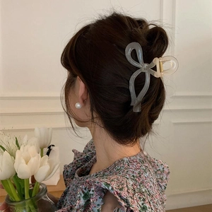 Elegant grey frosted bow hair claw clip for women shown on model hair style