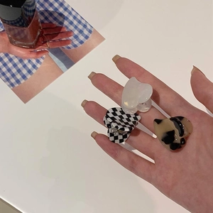 Three mini heart hair claws in checkerboard, pearl white and tortoiseshell patterns