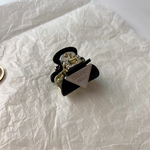 Detail view of mini black glossy hair claw clip with Modern Girls triangle plaque