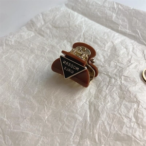 Elegant caramel brown acetate hair claw clip with vintage triangular logo design