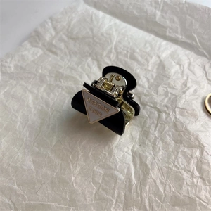 Small black hair claw clip for women featuring gold spring and modern girl text detail