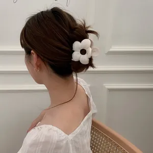 Vista posteriore di una modella con una molletta per capelli a fiore bianco in un raccolto