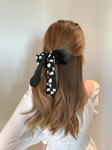 Detailansicht einer großen schwarz-weißen Satin-Schleife für Haare am Pferdeschwanz