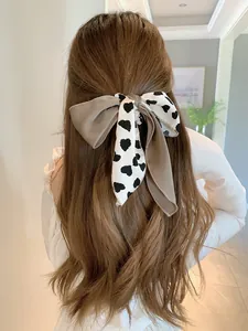 Detailansicht der gepunkteten Schleife mit Satinbändern an langem, gewelltem Haar