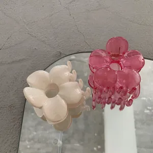 Primo piano dettagliato di mollette a fiore color crema e rosa traslucido su vassoio a specchio