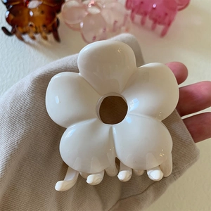 Close-up of white camellia flower hair claw clip with glossy finish and secure grip teeth