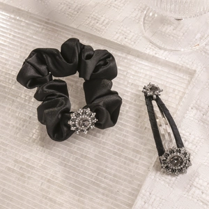 Detail of black satin scrunchie and hair clip set with vintage grey rhinestone flowers