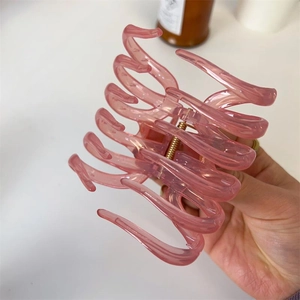 Elegant translucent pink large hair claw clip for thick hair shown in a hand-held display