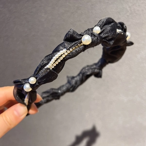 Détail du serre-tête noir fin en résille scintillante avec perles et chaîne de strass