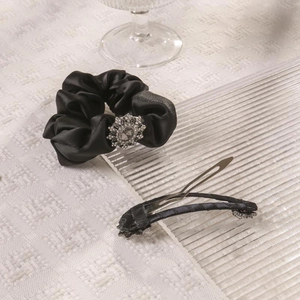 Elegant black satin scrunchie and hair clip set with sparkling rhinestone flower detail