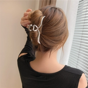 Pinza per capelli in metallo argento con design a cuore sulla pettinatura della modella