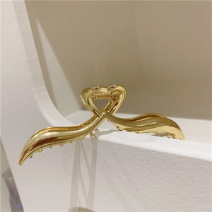 Pinza per capelli in metallo dorato lucido con un elegante design a forma di cuore