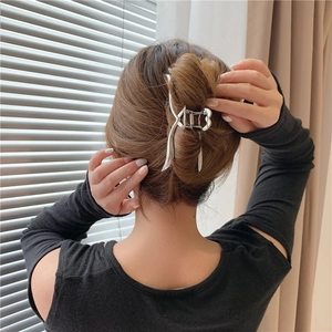 Dettaglio di una molletta per capelli in metallo argento ondulato su uno chignon