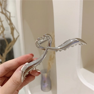 Dettaglio di un fermaglio per capelli argento con design a cuore e finitura lucida