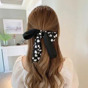 Eleganter Haargummi mit schwarz-weißen Punkten und langen Bändern für Pferdeschwänze