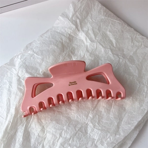 Close-up of pink oversized acetate hair claw clip with Barrette La France gold lettering