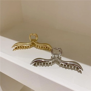 Eleganti fermagli per capelli incrociati in oro e argento con manico a cuore su base